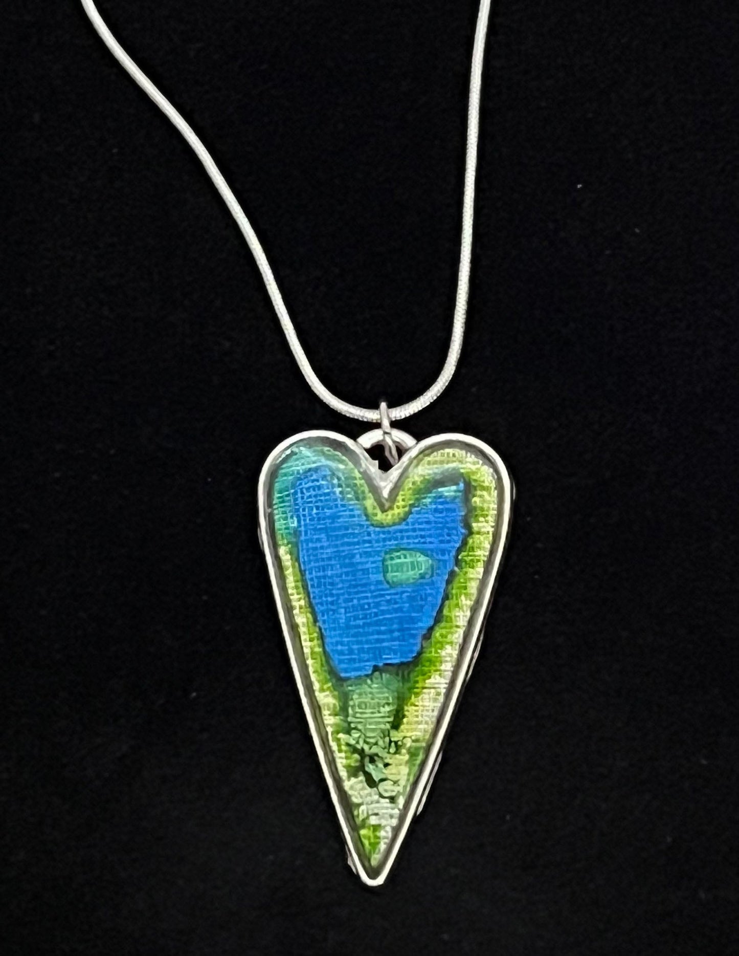 heart shaped silver pendant necklace with blue and green artwork