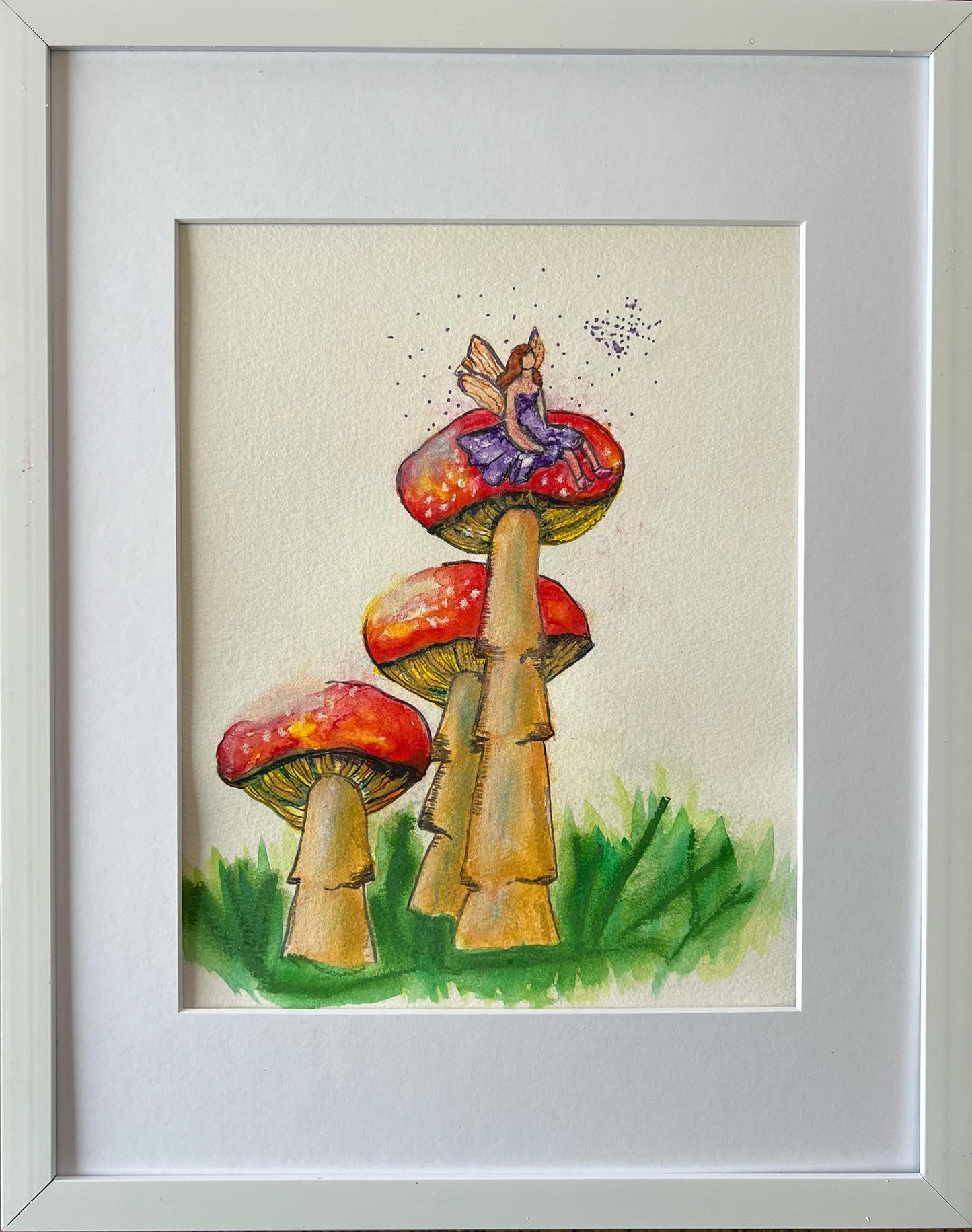 watercolor floral painting of red mushrooms with a fairy sitting on top